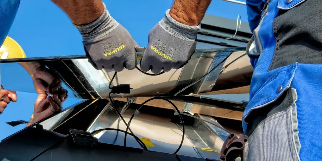 volunteers hold solar panels and work together to install solar farm